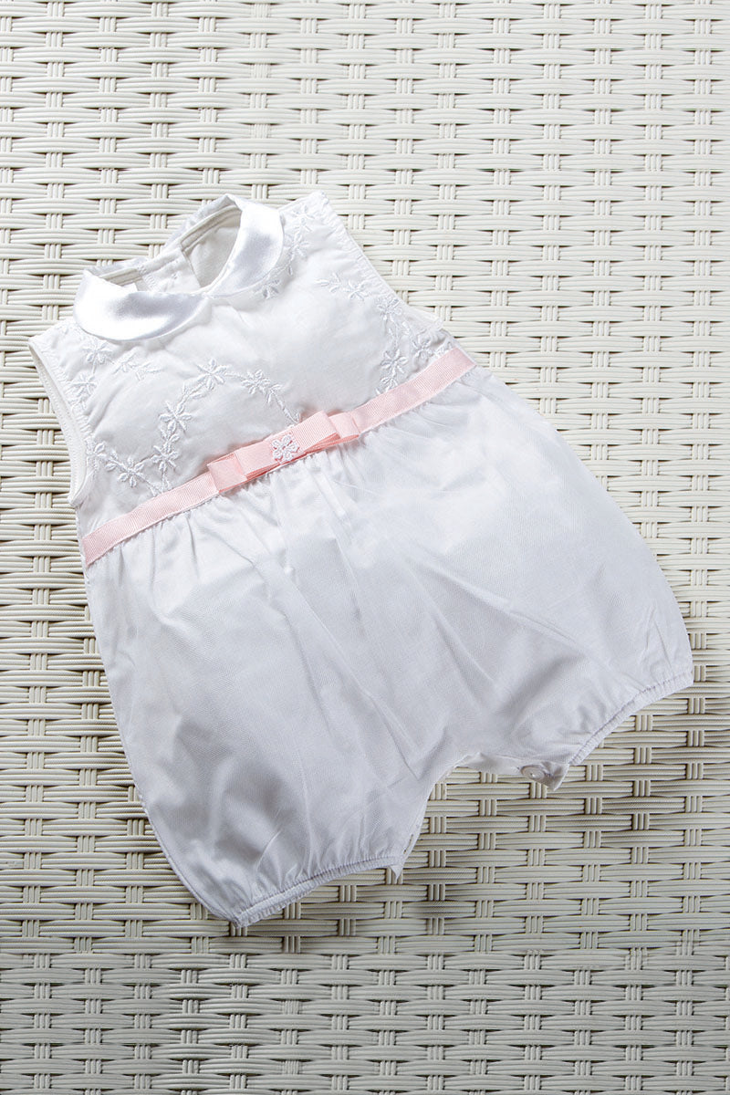 Pagliaccetto in tela di cotone ricamata con motivo floreale, nastro in gros grain con fiocco, applicazione ed inserto in tulle sovrapposto