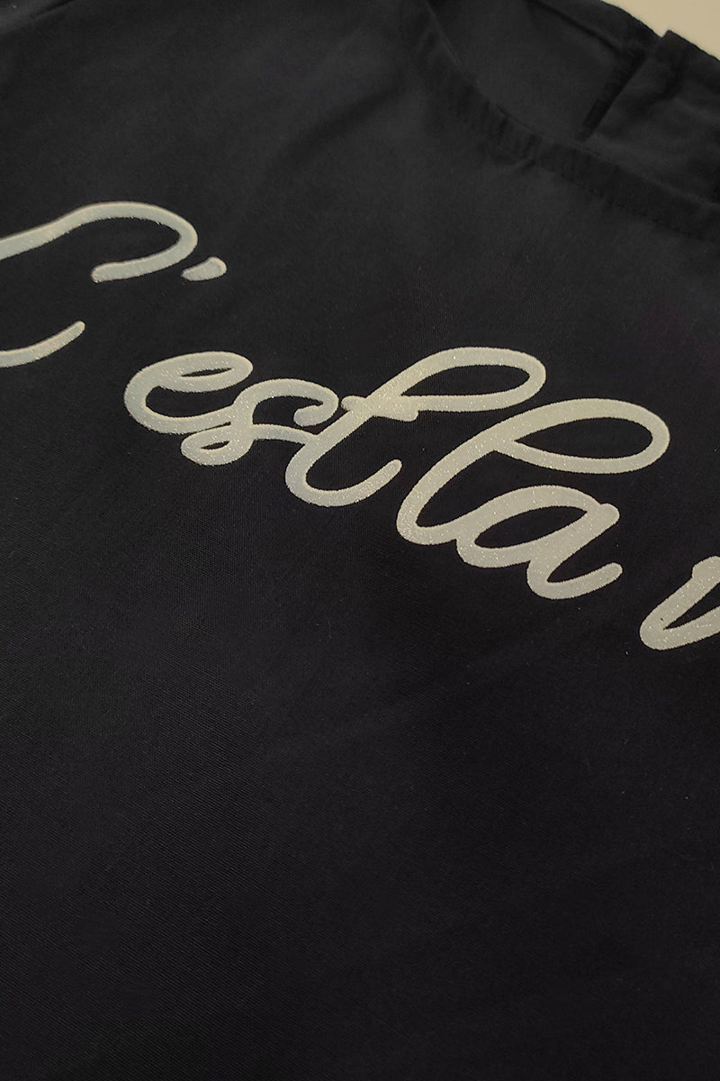 Vestitino in tela di cotone con balze sul fondo manica in tela rigata con fiocco e stampa effetto glitter con applicazione